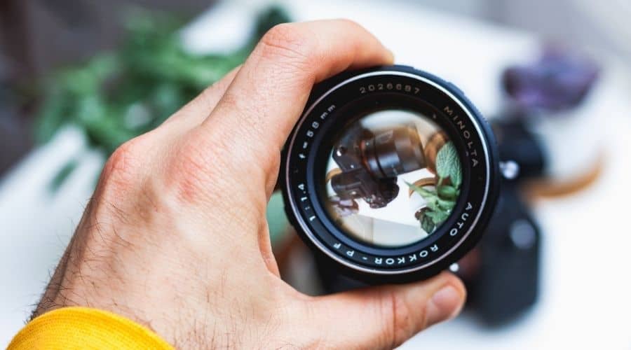 Someone holding camera lens on his hand