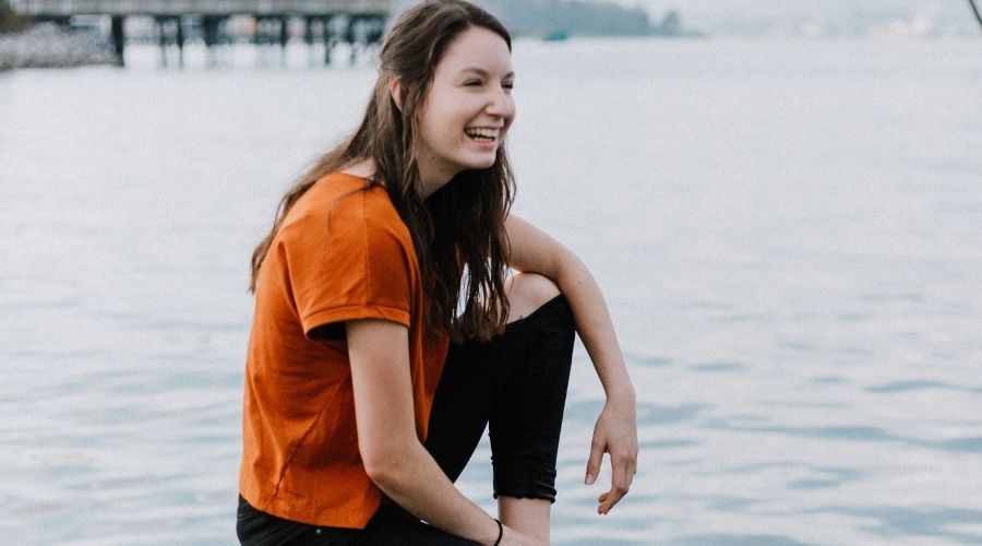 Smiling woman sitting on an edge - Capture Expressions And Emotions in portrait photo