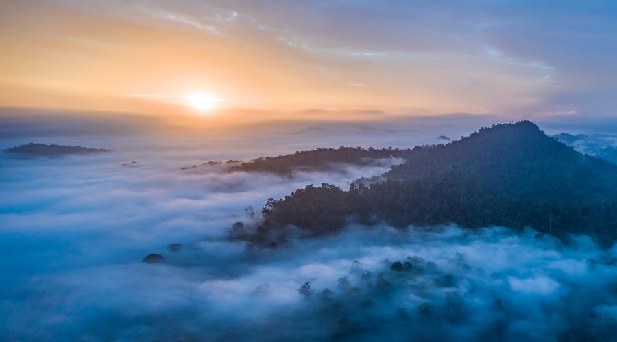 Long exposure photo of clouds streaking above a mountain